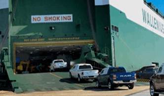 Heavy machinery driving onto RoRo ship for international transport
