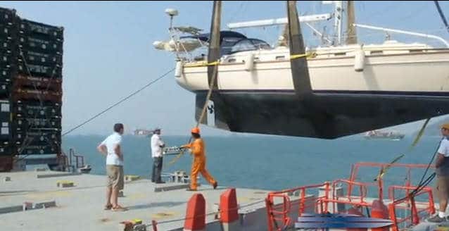 Leisure motorboat lifted by straps onto port dock